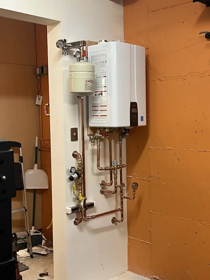 Plumbing technician inspecting water heater connections in Pittsboro
